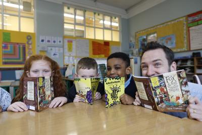 World Book Day launch with students and author/illustrator Paddy Donnelly holding copies of the Irish published WBD titles