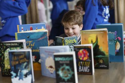 Eamonn from St Michael's School with the 2025 ten shortlisted titles for the KPMG Children's Books Ireland Awards