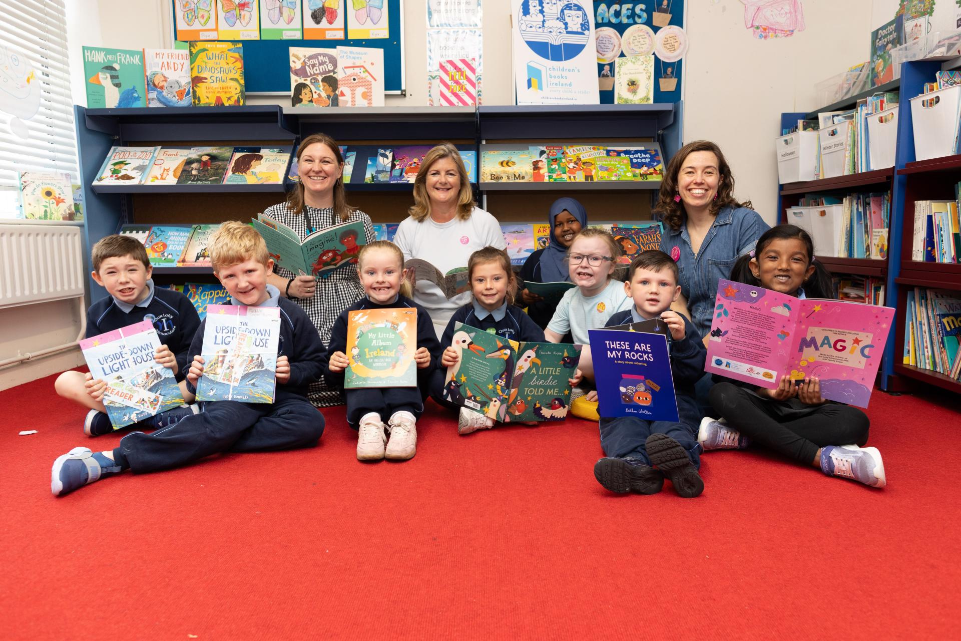 CEO, Chairperson and Tarsila with students in school library