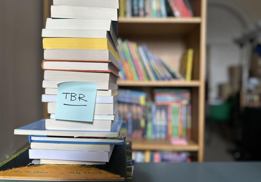 Stack of books with a 'TBR' post-it note attached to the front
