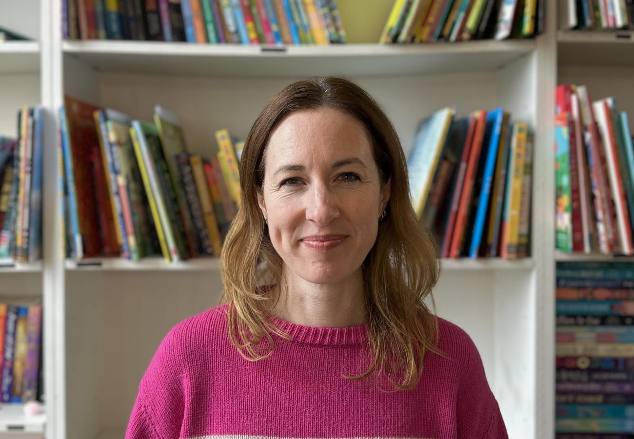 A woman standing in front of a bookshelf